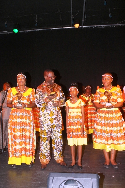 Le chef de chœur Ambroise Kua-Nzambi Toko et des choristes arborant les trois trophées de l’ African choral music Awards