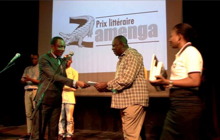 Serge Tshamala recevant son prix du parrain de la première édition, le député Serge Maabe