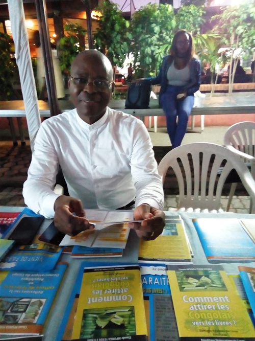 Claude Mpunga exposant ses opuscules à la 5e Fête du livre