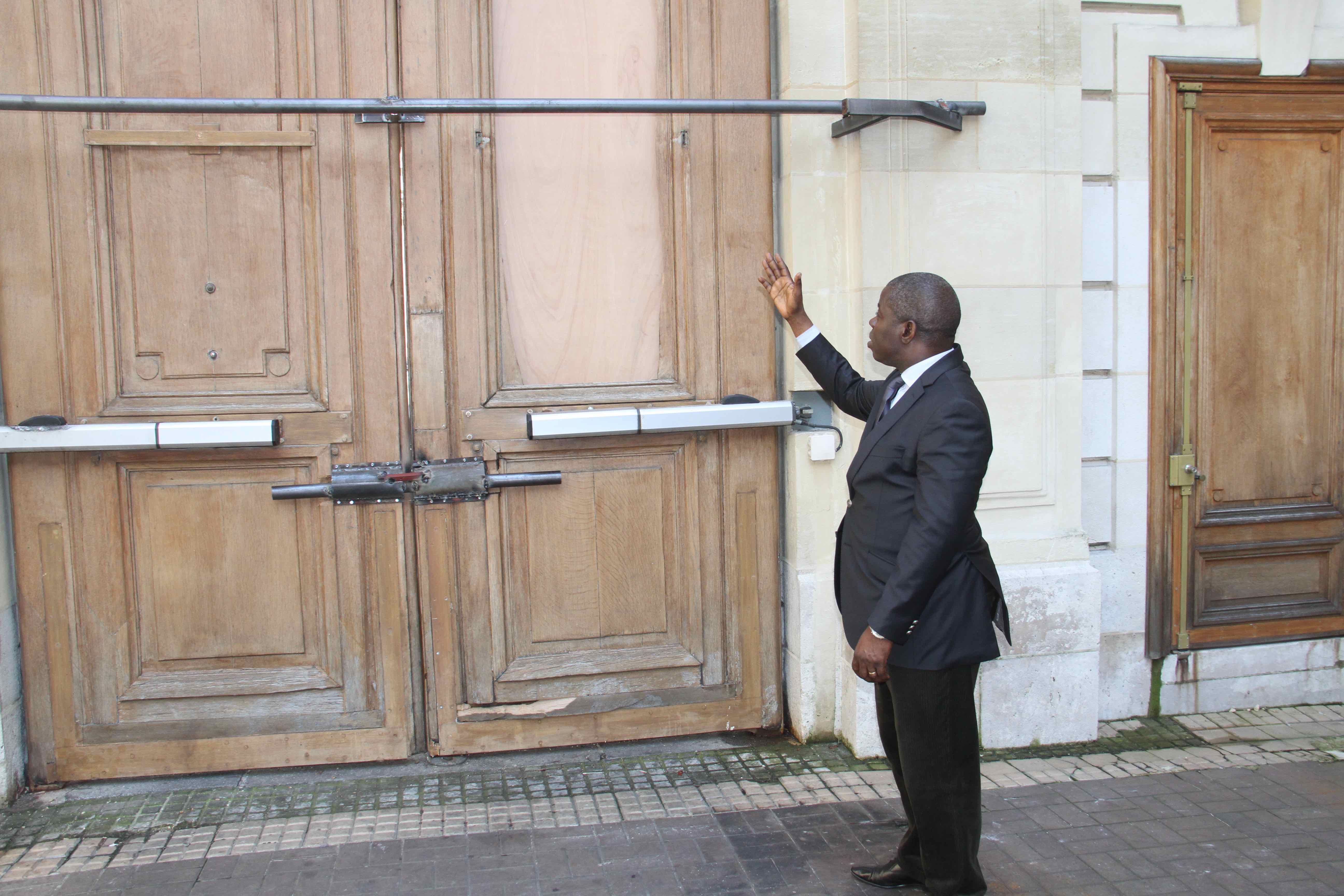 Anguios Nganguia Engambé devant la porte de l'ambassade du Congo en France