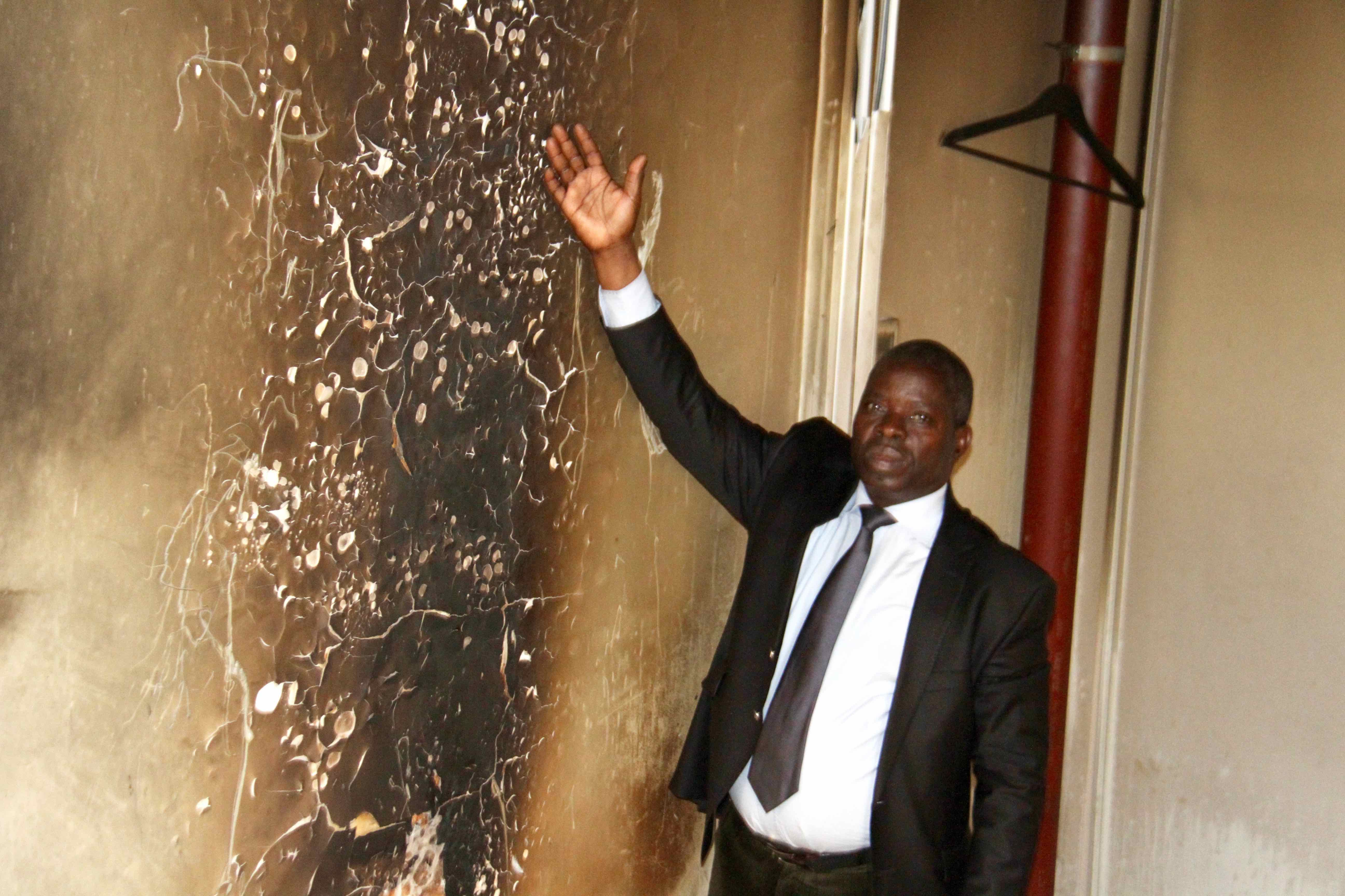 Anguios Nganguia Engambé devant la porte de l'ambassade du Congo en France  constatant les dégâts après le saccage du 21 juin