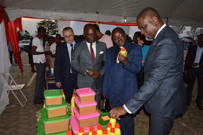 Le ministre rwandais du commerce et de l'industrie Vincent Munyeshyaka devant le stand Eco _Oil avec à la main une bouteille d'huile de palme