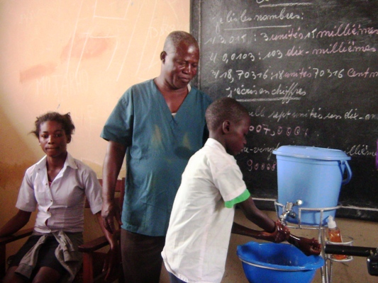 Un élève de 4e primaire en plein exercice pratique de lavage des mains sous l’œil vigilant du relais communautaire 