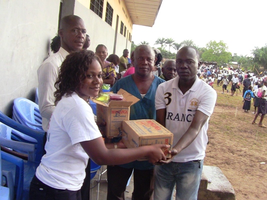 Stella Ramazani faisant don des cartons de savon à l’école pour le compte de Save the children