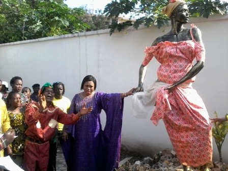 Marie-Josée Kazadi posant à côté de la statue mascotte de Maïsha industrie culturelle