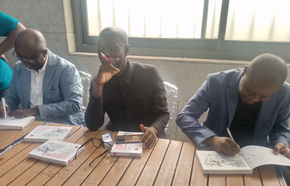 3 : Thembo Kash, Achille Bundjoko et Patient Ligodi dédicaçant leur ouvrage/ Adiac